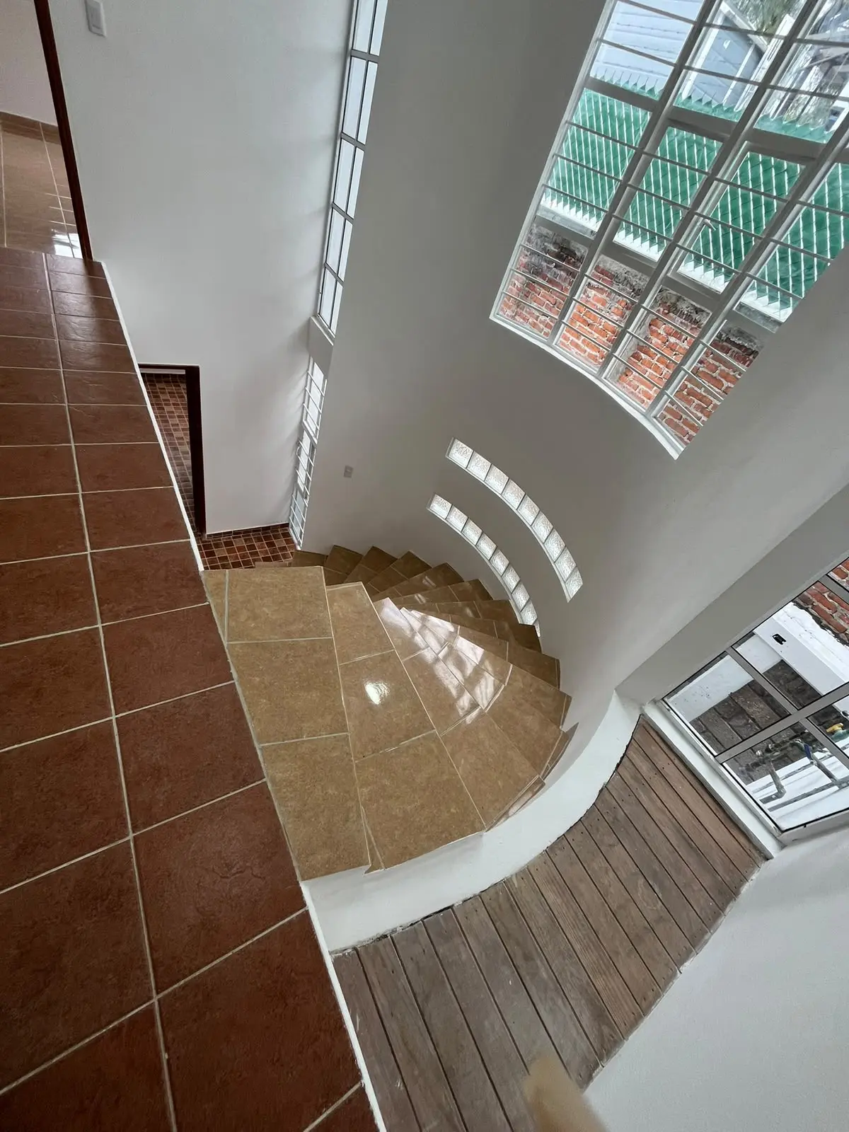 Escalera central iluminada por grandes ventanas